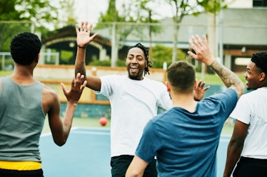 A group of men high-fiving each other after a game of dodgeball.