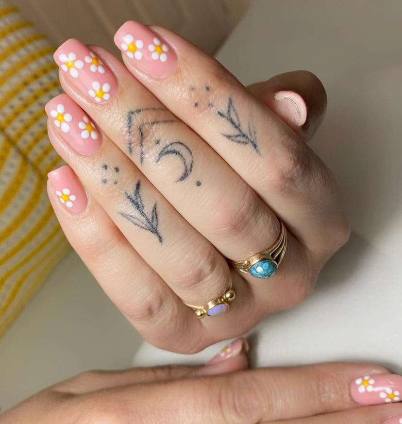 White and yellow daisy floral nail designs on a light pink background by Nails by Alice White on Ins...