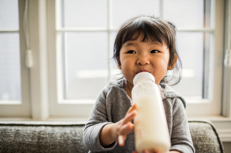 A toddler drinking from a baby bottle.