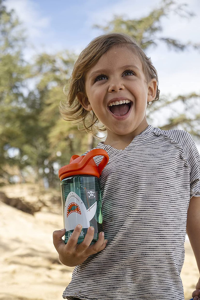 Girl holding CamelBak Eddy water bottle, one of the best kids water bottles on Amazon