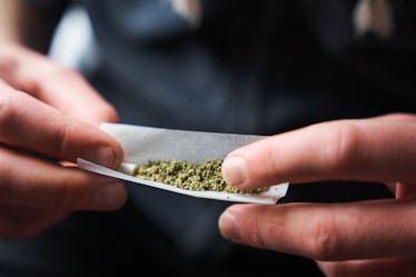 Close up of hands rolling a marijuana joint.