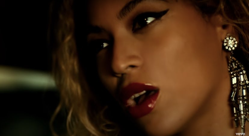 Beyoncé wears glamorous winged eyeliner and a red lip in the "Partition" music video.