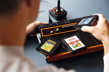 A man touching a Lego Atari 2600 set
