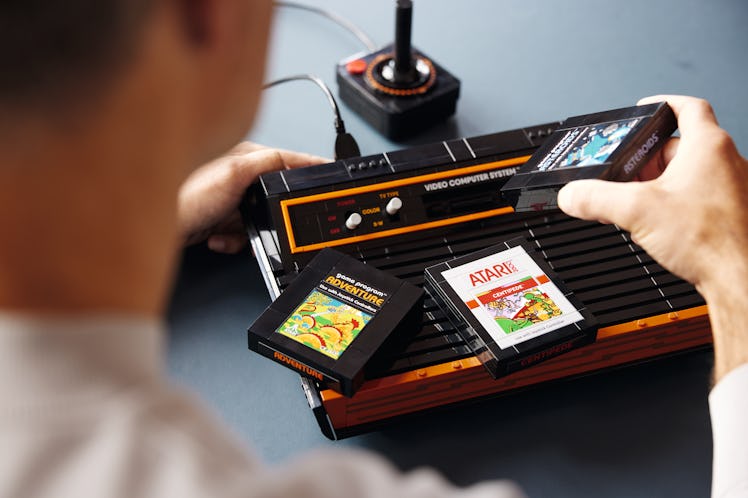 A man touching a Lego Atari 2600 set