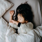 A toddler sleeping in bed.