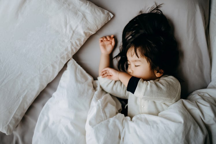 A toddler sleeping in bed.