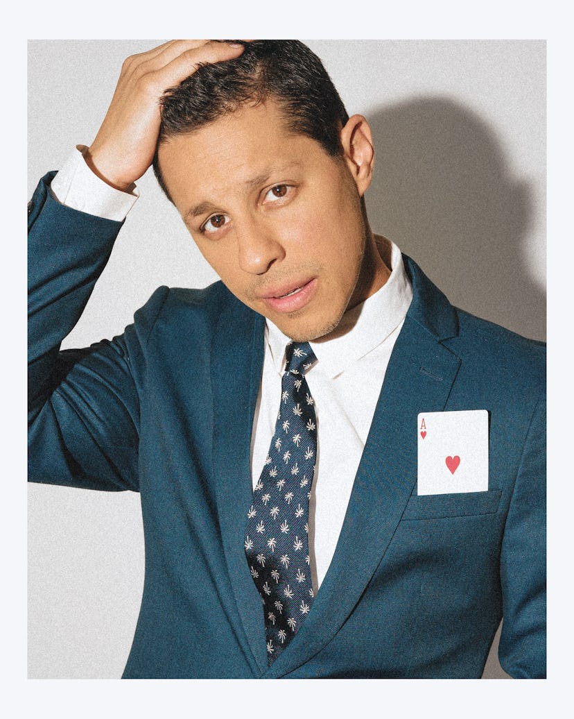 David del Rio wearing a navy suit with a playing card in his suit pocket