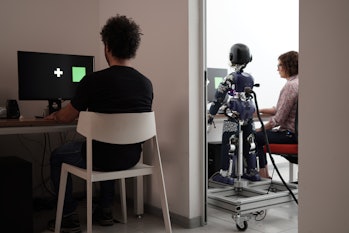 man on a computer with a robot a room over