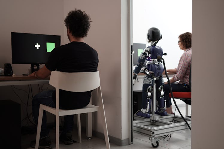 man on a computer with a robot a room over