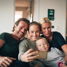 A family with a teen and a young boy pose for a photo.