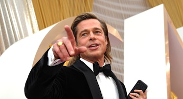 Brad Pitt in a tux doing a point with his fingers. 