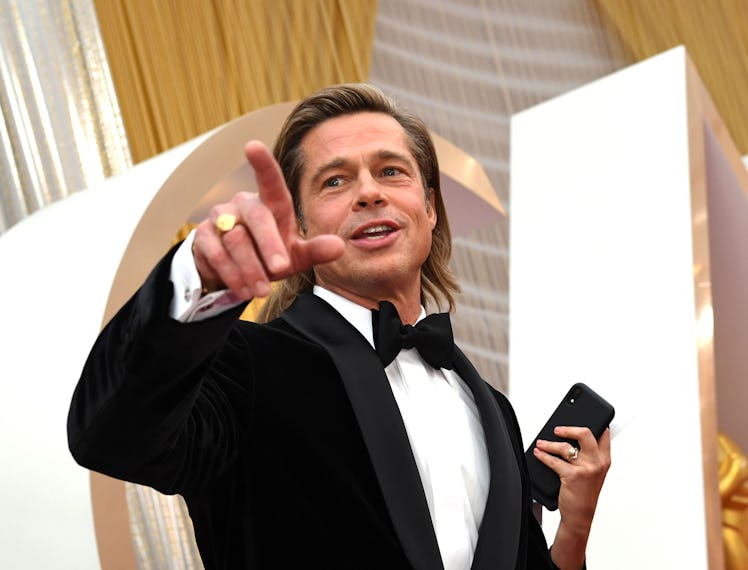 Brad Pitt in a tux doing a point with his fingers.