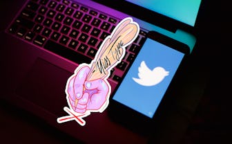 Twitter screen on a phone atop a laptop keyboard.