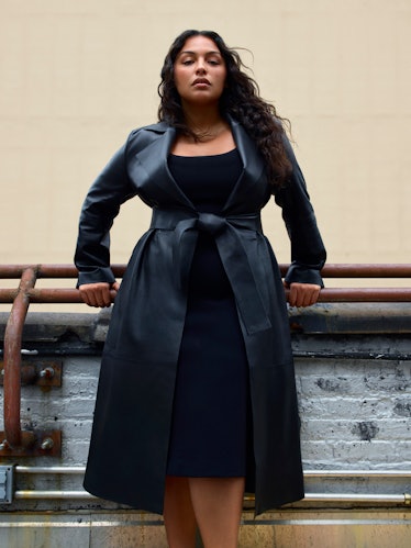 Paloma Elsesser wearing a belted black coat in a COS campaign