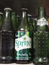 A lineup of vintage green Sprite bottles. Coca-Cola announced that the lemon lime soda will now come...