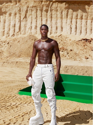 A shirtless model wearing towering white platform boots in a Balmain campaign