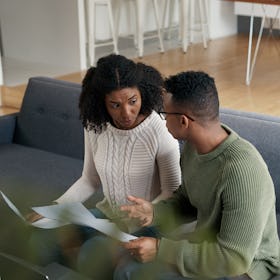 Young black couple having serious discussion on couch