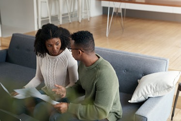 Young black couple having serious discussion on couch