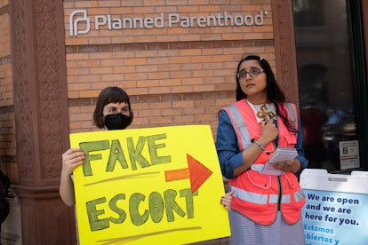 Abortion-rights and anti-abortion supporters stand outside of a Planned Parenthood abortion clinic, ...