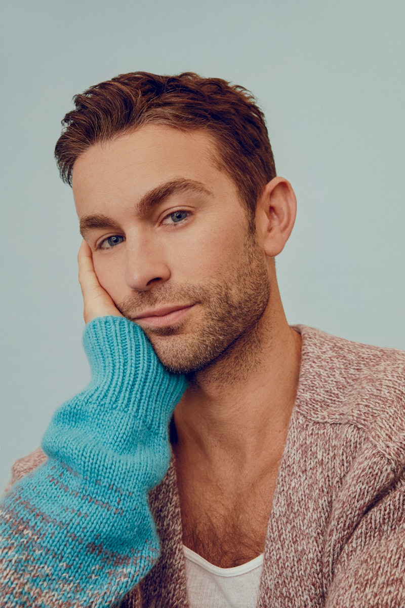 Chace Crawford posing in a light brown and blue cardigan