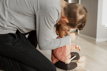 A dad uses a tissue to get rid of his baby's snot.