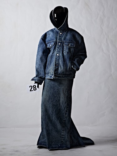 A model in a Balenciaga denim jacket and long denim skirt with a black plexiglass face shield