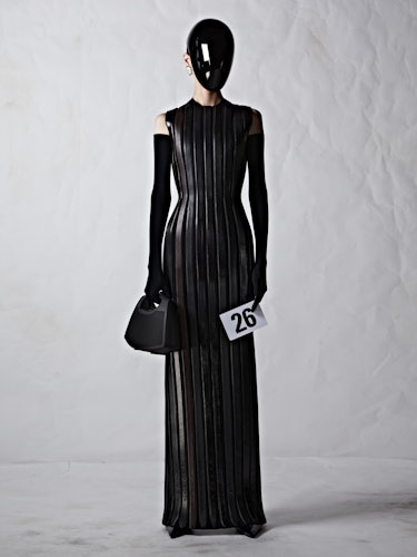 A model in a black, leather Balenciaga dress with a black plexiglass face shield
