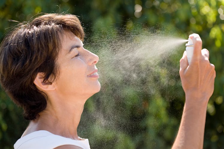 Woman spraying herself with water