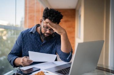 Man looking worried as he reads his financial statements