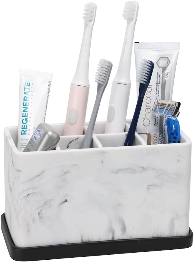 marble effect toothbrush and toothpaste holder with items inside