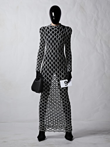 A model in a gray chain-like Balenciaga dress with a black plexiglass face shield