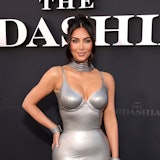 Kim Kardashian wearing a silver dress on a red carpet