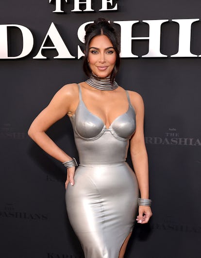 Kim Kardashian wearing a silver dress on a red carpet