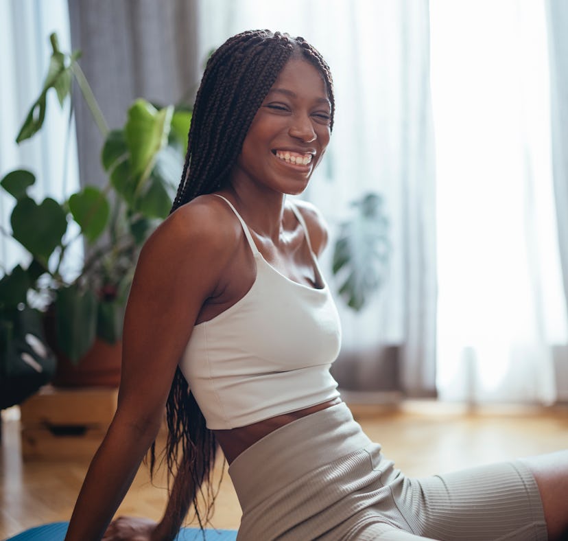 A woman performs a quick pilates workout for summer 2022 at home, according to a celebrity pilates t...