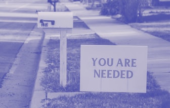 A poster with the text 'You are needed' next to a letterbox on a street