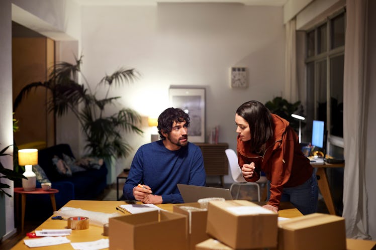 A young man and a woman talking over the table showing signs one's being defensive