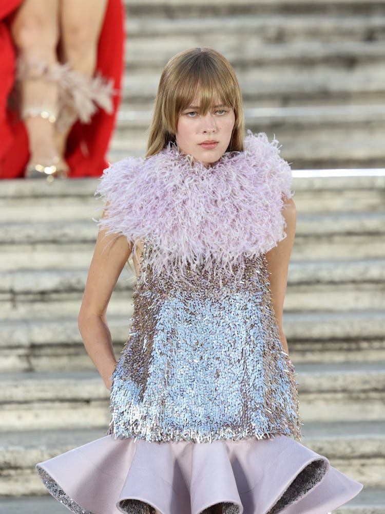 A model walking on the runway in a purple dress at the Valentino haute couture fall/winter 22/23 fas...
