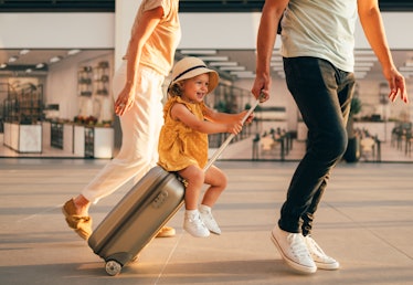 A little girl strolls through the airport with her parents. 