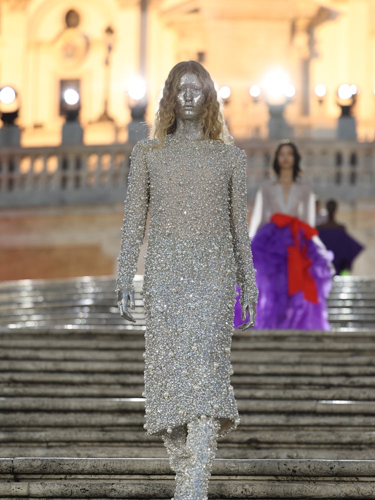 A model walking on the runway in a silver dress at the Valentino haute couture fall/winter 22/23 fas...