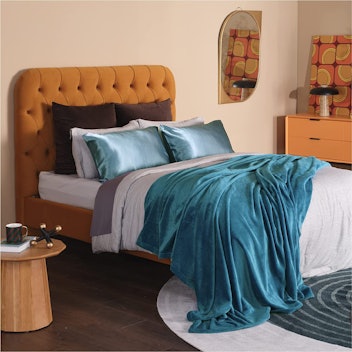 Teal Bedsure Fleece Blanket, a great gift for college students, on bed