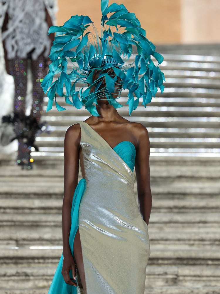 A model walking on the runway in a silver and blue gown at the Valentino haute couture fall/winter 2...