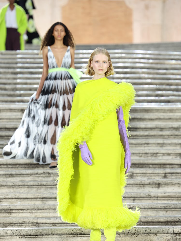 Two models walking on the runway at the Valentino haute couture fall/winter 22/23 fashion show 