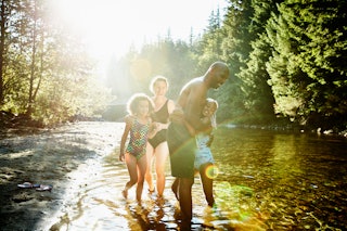 A family enjoys spending time together in the river during summer.