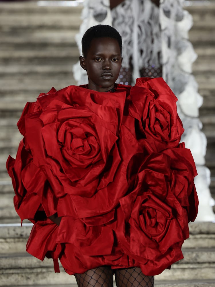 A model walking on the runway in a rose-shaped dress at the Valentino haute couture fall/winter 22/2...