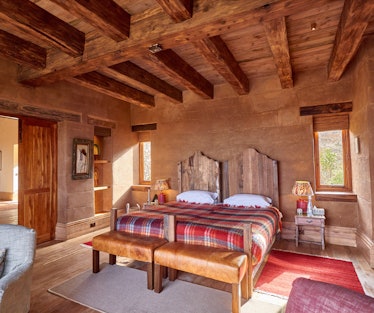 a hotel room at Lengishu Lodge, Nairobi.  The ceiling has rustic exposed beams, the...
