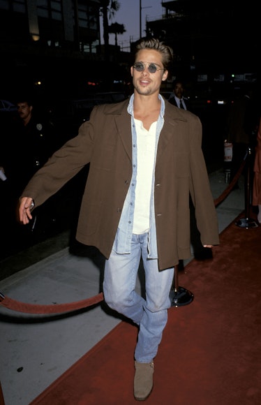 Brad Pitt wearing a brown blazer and jeans on a red carpet