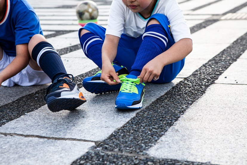 Kid are tying the laces on their sneakers. Recreational sports are vital to kids in many communities...