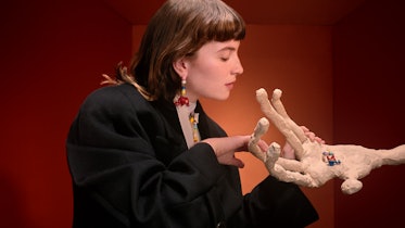 Isadora Bjarkardóttir Barney touching a sculpture of a hand in a Miu Miu campaign