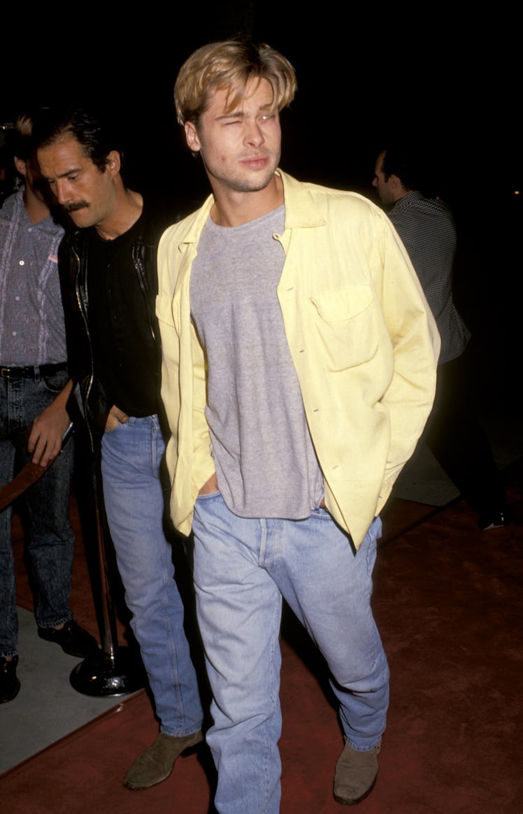 Brad Pitt wearing a yellow shirt and jeans on a red carpet