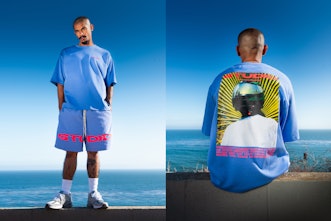 Supervsn Studios Model posing in a blue set with pink text on it.